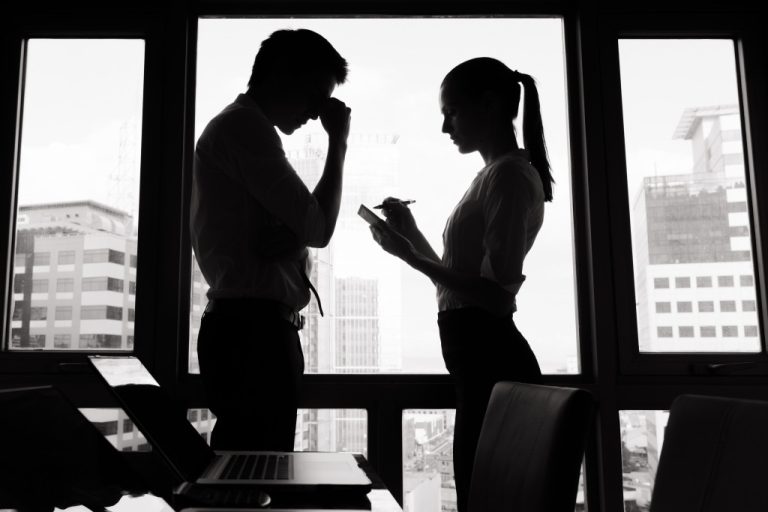 Stressed businessman and woman arguing in an office